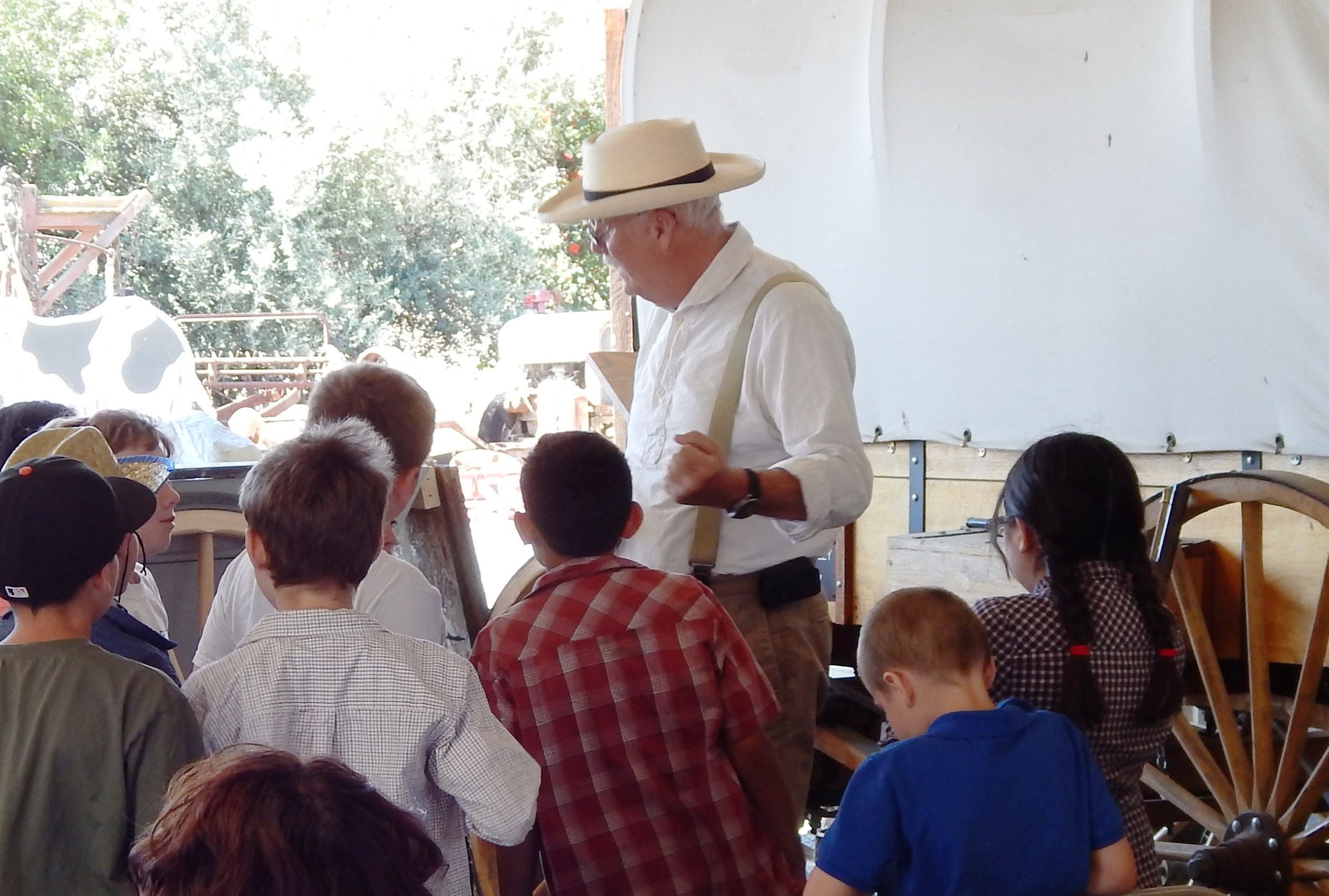 Students in front of one-room schoolhouse with School Marm